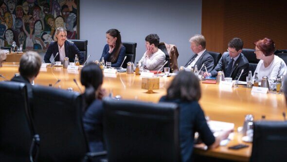 Einige Ratsmitglieder sitzen an einem Tisch im Büro und besprechen das neue Arbeitsprogramm.